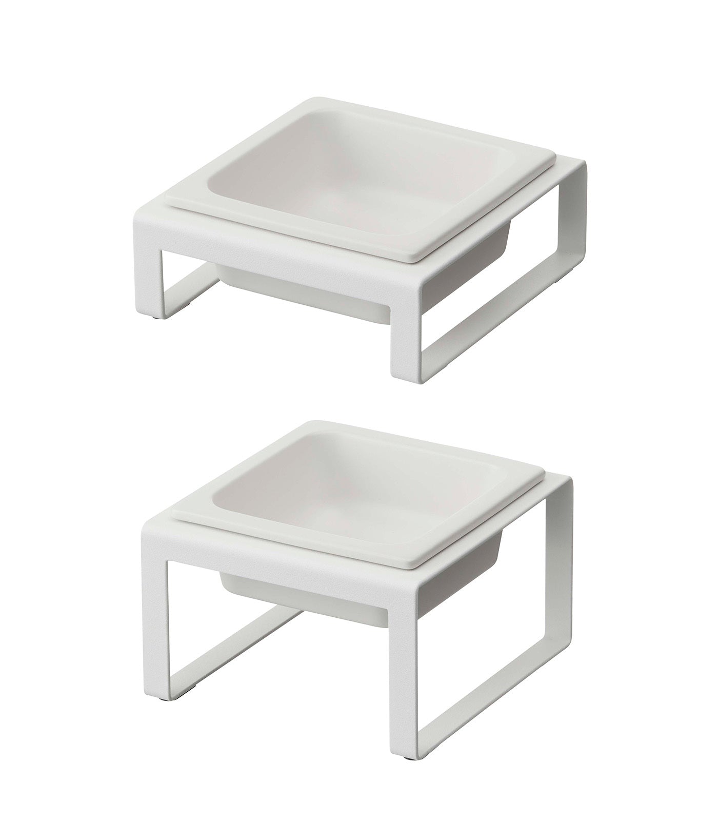 Two minimalist Yamazaki Home white ceramic square bowls feature a shallow design, each on a matching rectangular base. These modern pet food bowls offer clean lines and an elevated structure, combining function with sleek aesthetics.