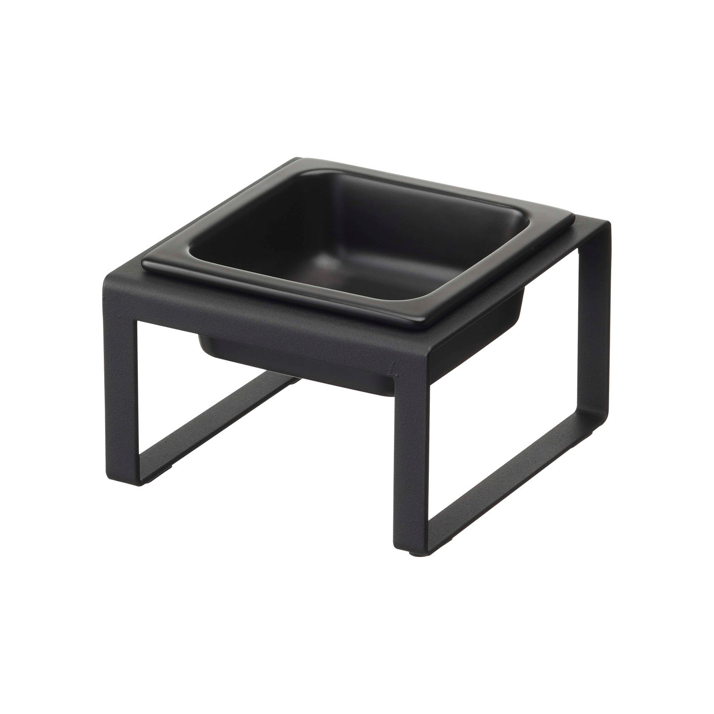 The Yamazaki Home Single Pet Food Bowl, available in an elegant ceramic style, boasts a modern black square design with open sides. It includes non-scratch silicone protectors and sits gracefully on a white background.