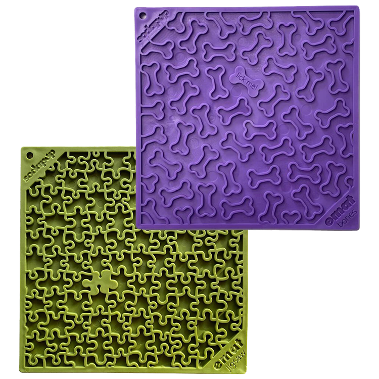 The image features a bundle from SodaPup, including the Large Purple Bones EMat with bone-shaped indentations and the Large Green Jigsaw EMat with a more intricate pattern. These silicone lick mats are crafted for dog enrichment, assisting in slowing down eating habits to improve digestion and offer mental stimulation.