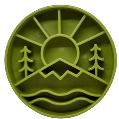 The SodaPup Great Outdoors Design EBowl is a round green plastic slow feeder dog bowl with sun, mountains, pine trees, and water motifs for a nature-inspired look that encourages slower eating.