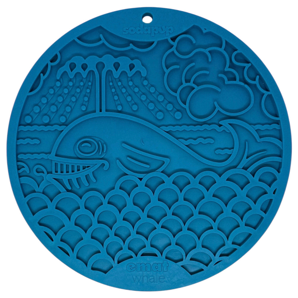 The Whale Design EMat Enrichment Lick Mat With Suction Cups by SodaPup features a blue, round silicone mat with a smiling whale and ocean scene—ideal for enrichment or bath time distractions. "SodaPup" and "emati whale" are embossed on the mat.
