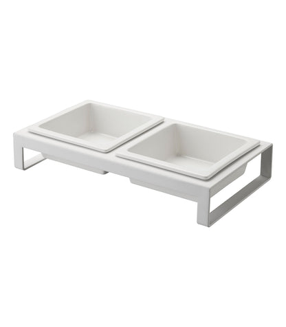 White ceramic dual-compartment Yamazaki Home pet food bowl on a frame.