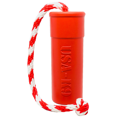 The SodaPup USA-K9 Firecracker Durable Rubber Floating Training Dummy in large red features a cylindrical shape with "USA-K9" embossing, attached to a red and white braided rope—ideal for interactive water fetch and play.
