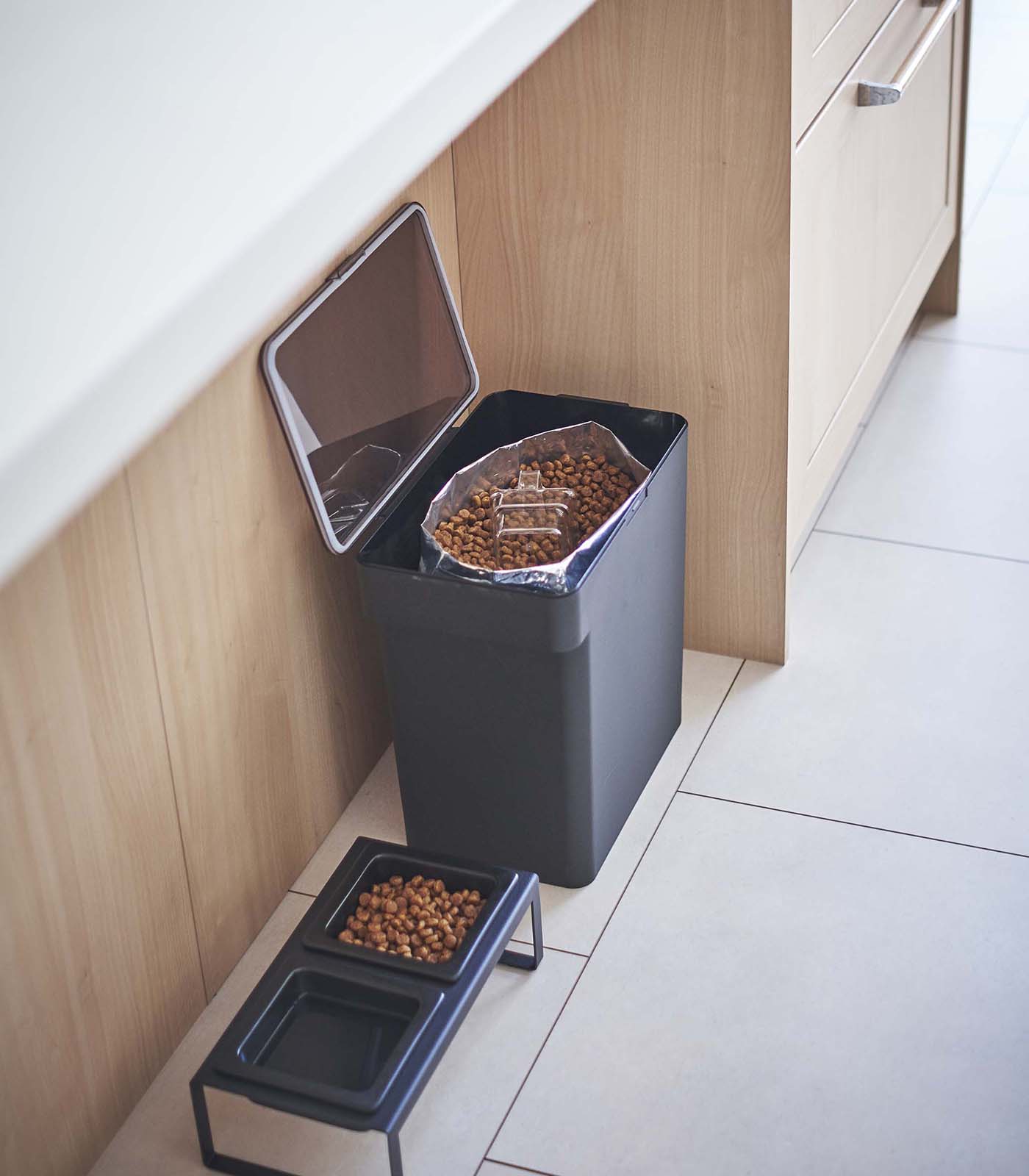 A kitchen with a Yamazaki Home Airtight Pet Food Container - Three Sizes on the floor.