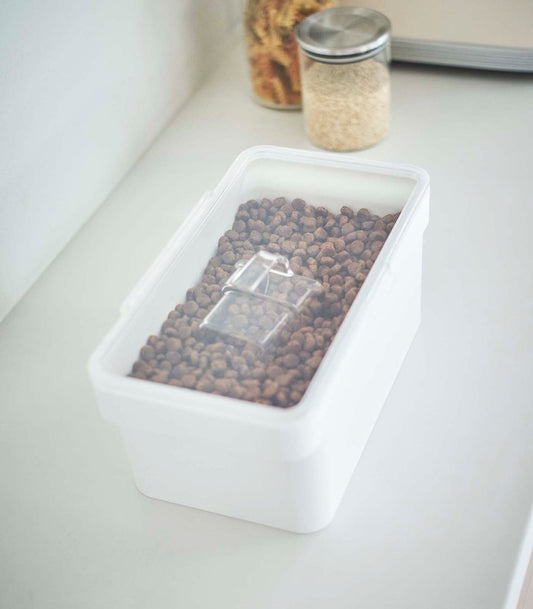 A Yamazaki Home Airtight Pet Food Container - Three Sizes with a lid on it for storing kibble.