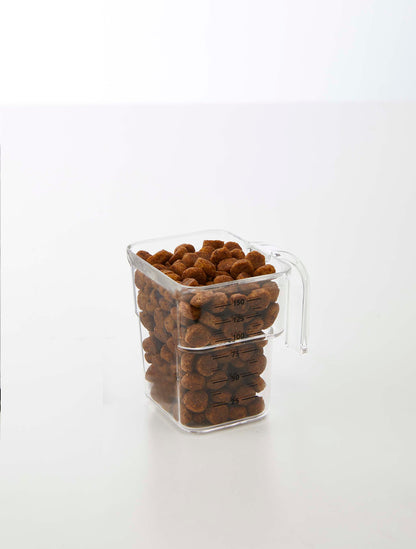 A Yamazaki Home Airtight Pet Food Container - Three Sizes filled with almonds on a white surface.