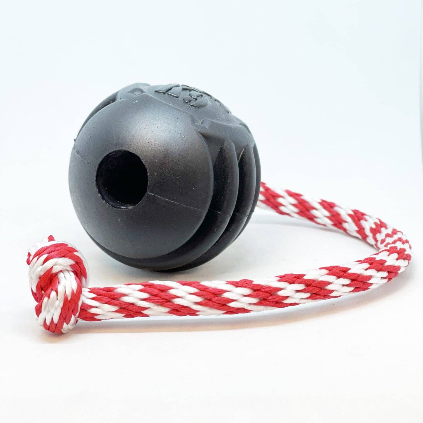 A SodaPup USA-K9 Magnum Black Stars and Stripes Ultra-Durable Rubber Chew Toy, Reward Toy, Tug Toy, and Retrieving Toy - Black with red and white dental ridges attached to it, perfect for power-chewer large dogs.