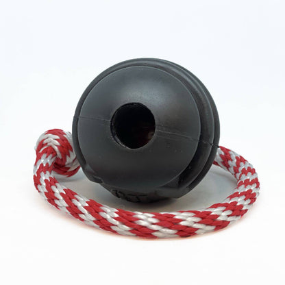 A USA-K9 Magnum Black Stars and Stripes Ultra-Durable Rubber Chew Toy, Reward Toy, Tug Toy, and Retrieving Toy - Black with dental ridges and a red and white rope attached to it. Brand Name: SodaPup