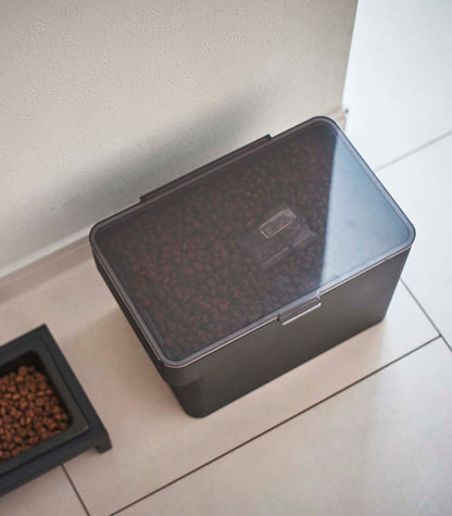 A Yamazaki Home Airtight Pet Food Container - Three Sizes on a tile floor.