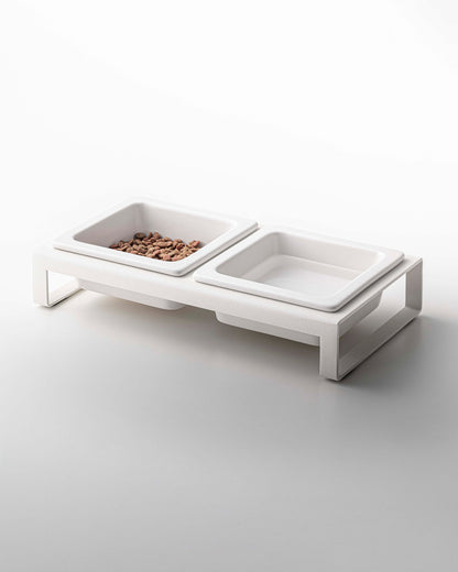 Two Yamazaki Home ceramic pet food bowls on a white surface.