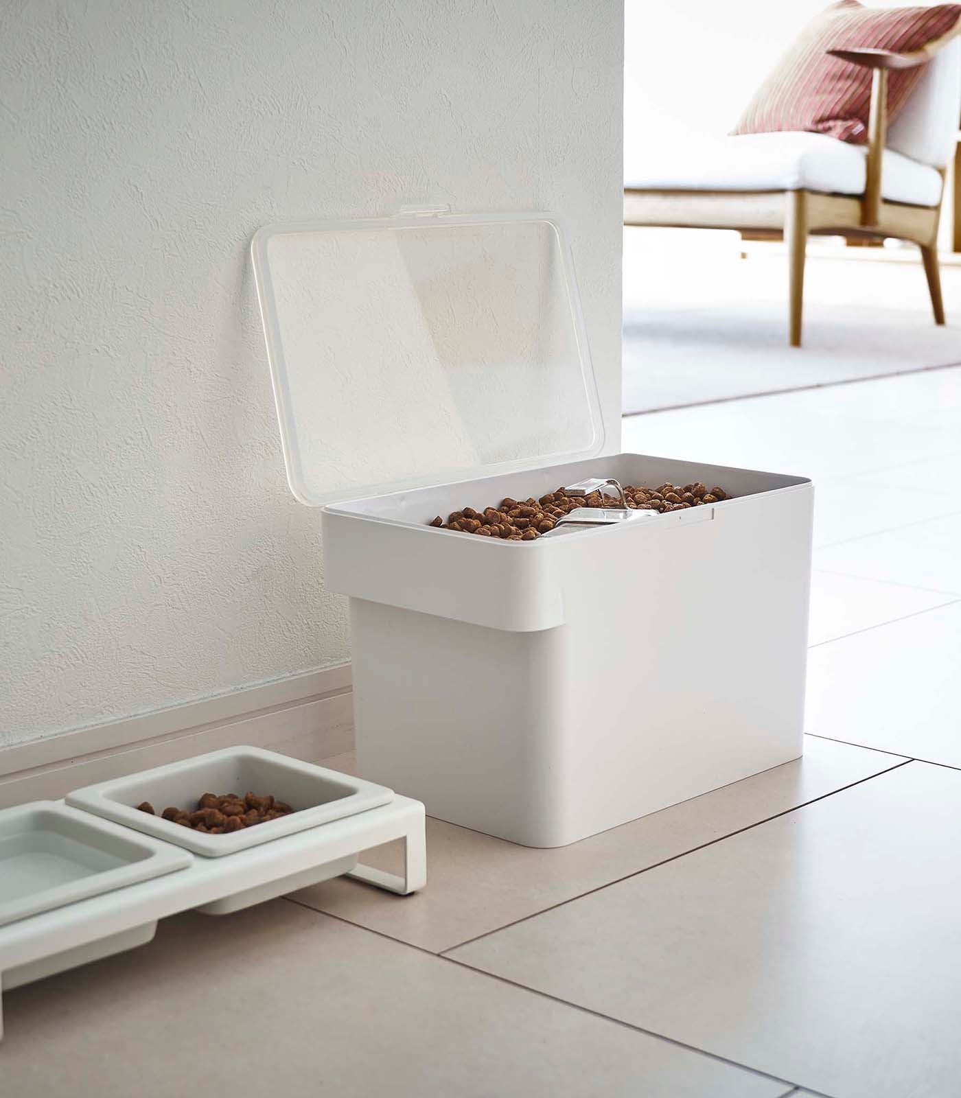 A Yamazaki Home Airtight Pet Food Container - Three Sizes on a white floor.