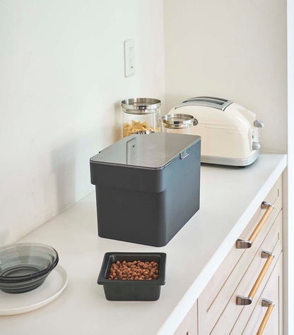 A kitchen counter with a Yamazaki Home Airtight Pet Food Container - Three Sizes and a toaster.