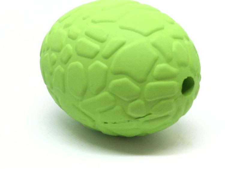 A vibrant green Dinosaur Egg EDispenser from SodaPup, made of textured rubber and designed to look like a dino egg treat dispenser, showcases a bumpy surface with a small hole on one side. This durable chew toy is displayed against a simple white background.