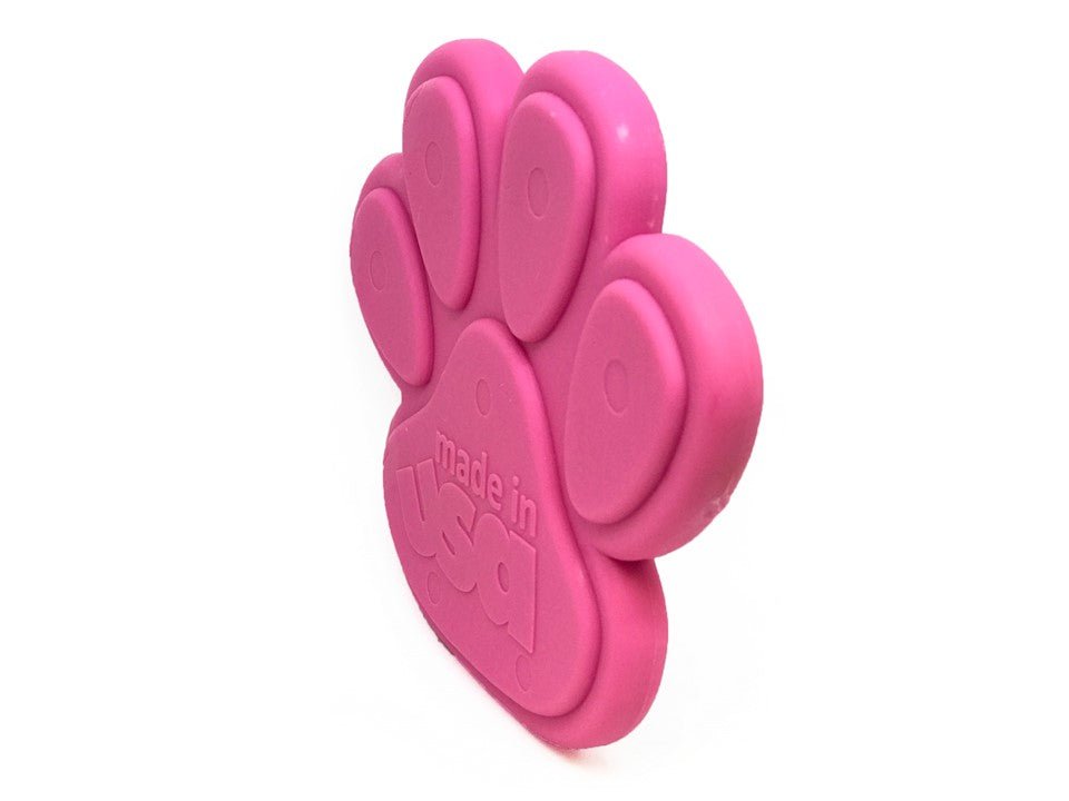 A durable and non-toxic Paw Print Ultra Durable Nylon Dog Chew Toy in pink, branded by SodaPup, shaped like a dog paw on a white background.