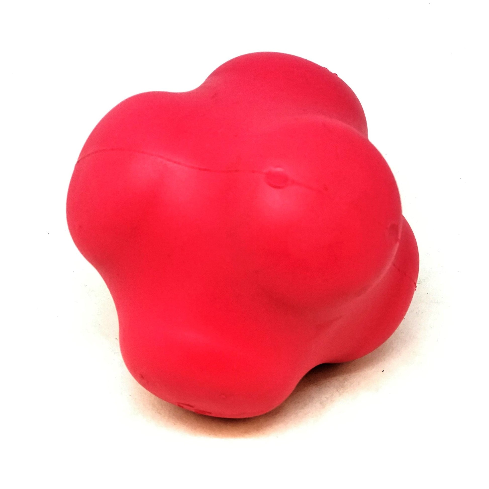 A red Crazy Bounce Ultra Durable Rubber Chew & Retrieving Toy by SodaPup sitting on a white surface.