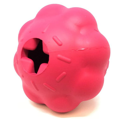 Introducing the Cupcake EDispenser by SodaPup, a durable rubber chew toy in a vibrant pink hue. This innovative dog toy features a textured hollow sphere design with star-shaped openings, making it ideal for dispensing treats and serving as a slow feeder during playtime.