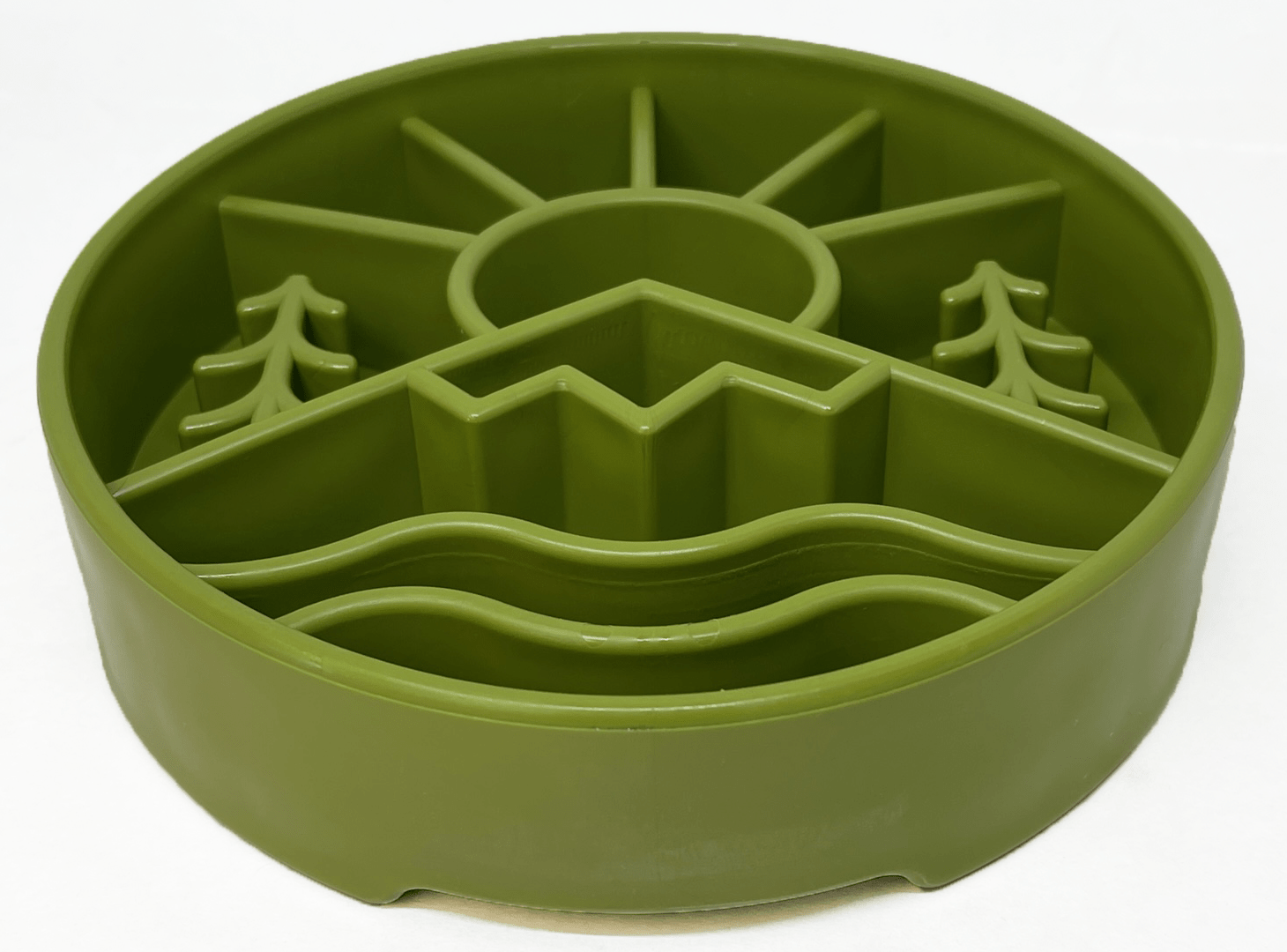 The Great Outdoors Design EBowl Enrichment Slow Feeder Bowl for Dogs by SodaPup is a green circular silicone mold featuring a sun, mountains, two pine trees, and wavy water at the base. This slow feeder bowl is divided into six sections with raised outlines to shape the different elements, promoting healthy slower eating for your pet.