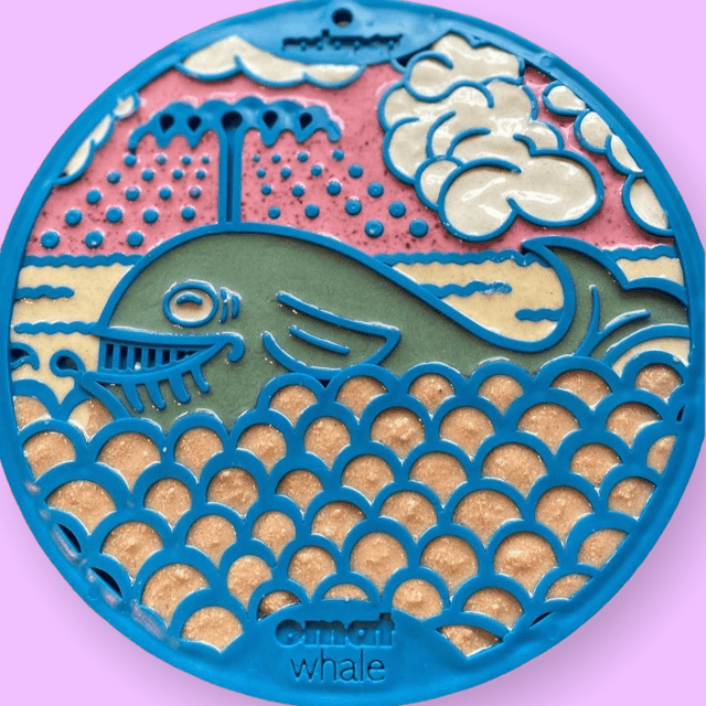 A blue plate with an image of a SodaPup whale design EMat Enrichment Lick Mat With Suction Cups on it, perfect for dog owners during bath time.