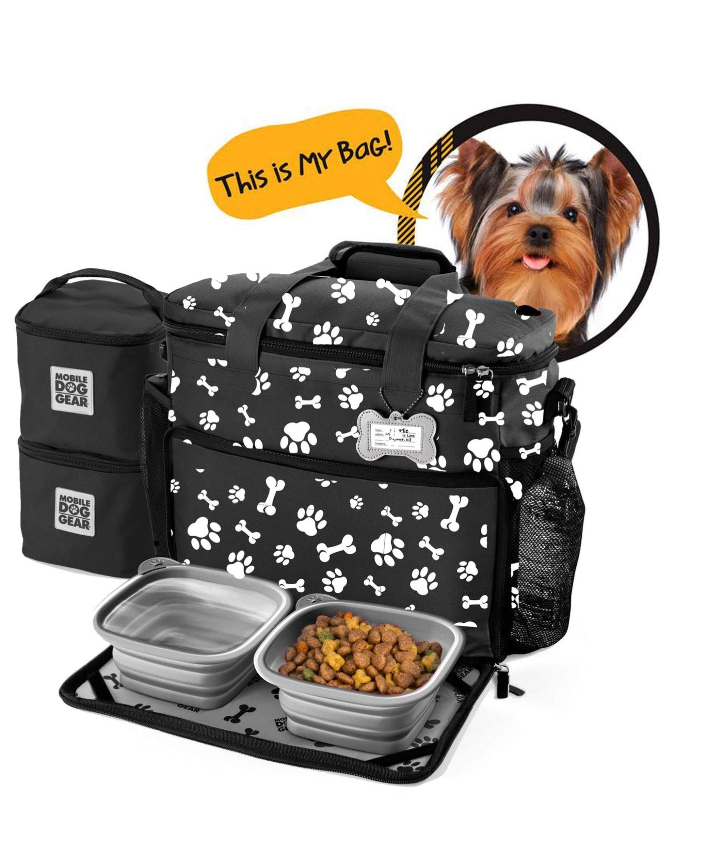 A Small Week Away® Tote Bag by Mobile Dog Gear with a paw print design, displayed with compartments open showing collapsible dog bowls and a storage bin. A speech bubble from a small dog's head says, "This is my bag.