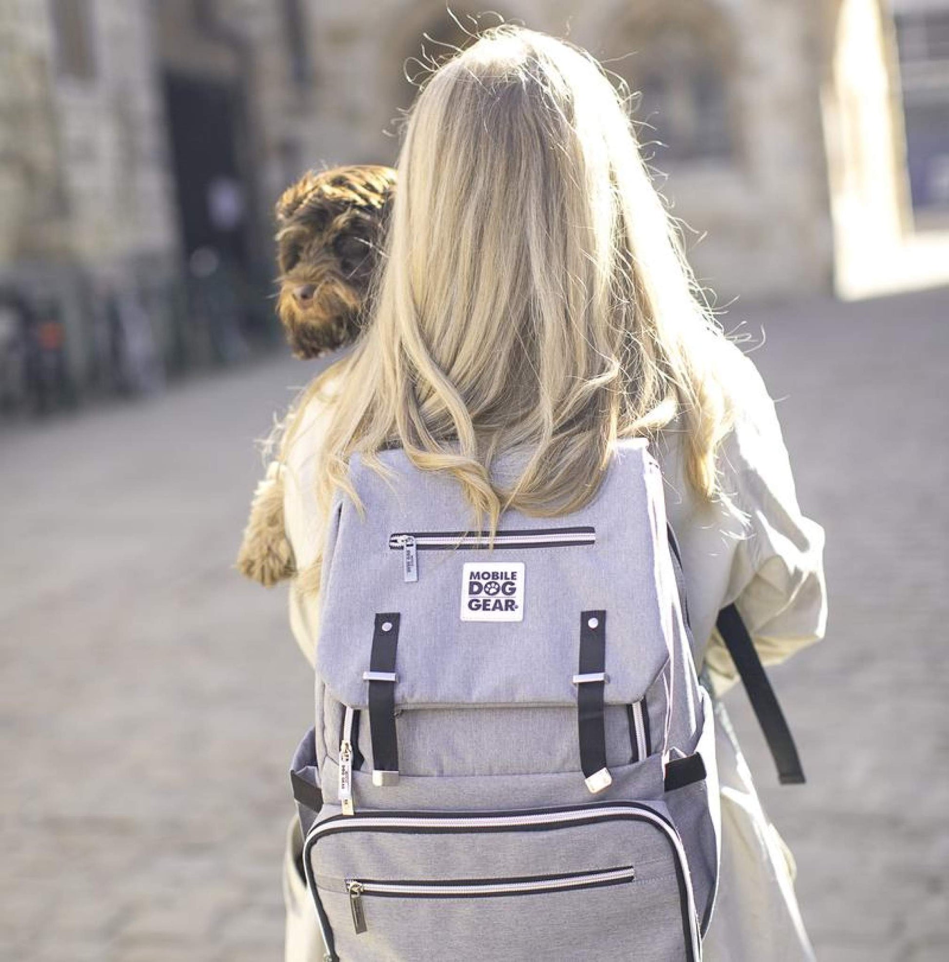 A woman wearing a Mobile Dog Gear Ultimate Week Away Backpack with a dog on her back.