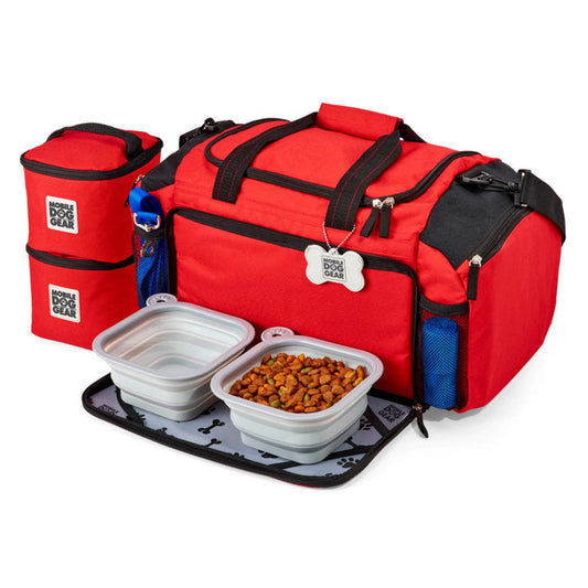 A Mobile Dog Gear Ultimate Week Away® Duffle for outdoor adventures with dog food containers and bowls.