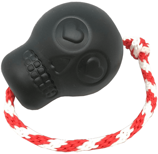 A SodaPup USA-K9 Magnum Skull Durable Rubber Chew Toy, Treat Dispenser, Reward Toy, Tug Toy, and Retrieving Toy - Black Magnum featuring a black and white Day of the Dead sugar skull design, with a rope attached for added fun.