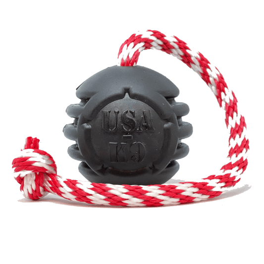 A SodaPup Magnum Black Stars and Stripes Ultra-Durable Rubber Chew Toy, Reward Toy, Tug Toy, and Retrieving Toy - Black with dental ridges.