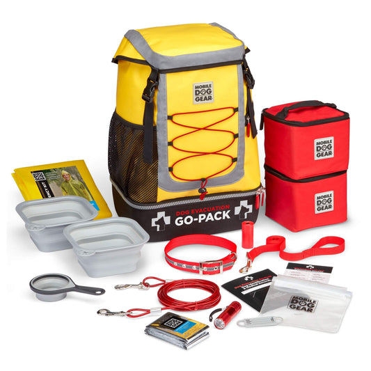A Mobile Dog Gear Large Dog Evacuation Go-Pack including a yellow and gray backpack, a red thermal bag, food containers, a leash, carabiners, first-aid supplies, and an instruction booklet.